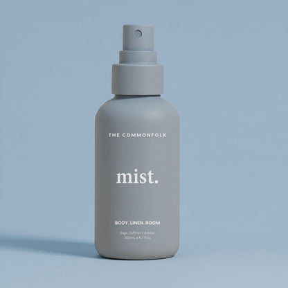 Denim color spray bottle labeled 'The Commonfolk' on a light blue background