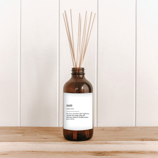 The Commonfolk room diffuser on a white wooden background, with text that reads 'sun' on a white label.
