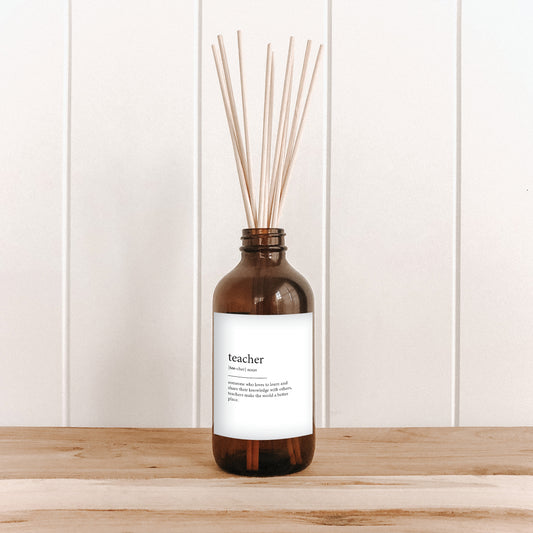 The Commonfolk room diffuser on a wooden surface and white wall background, with a text that reads 'teacher' with meaning.