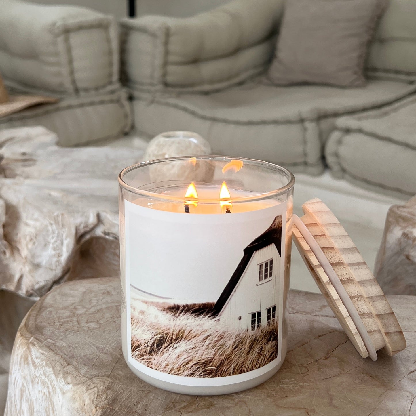 Candle with a scenic design on a stone surface in a cozy living room.