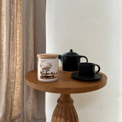 Small black lamp on a wooden stand with a white background