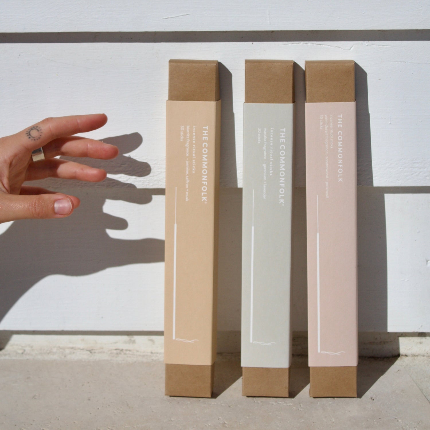 Three cylindrical boxes with different color finishes on a white background