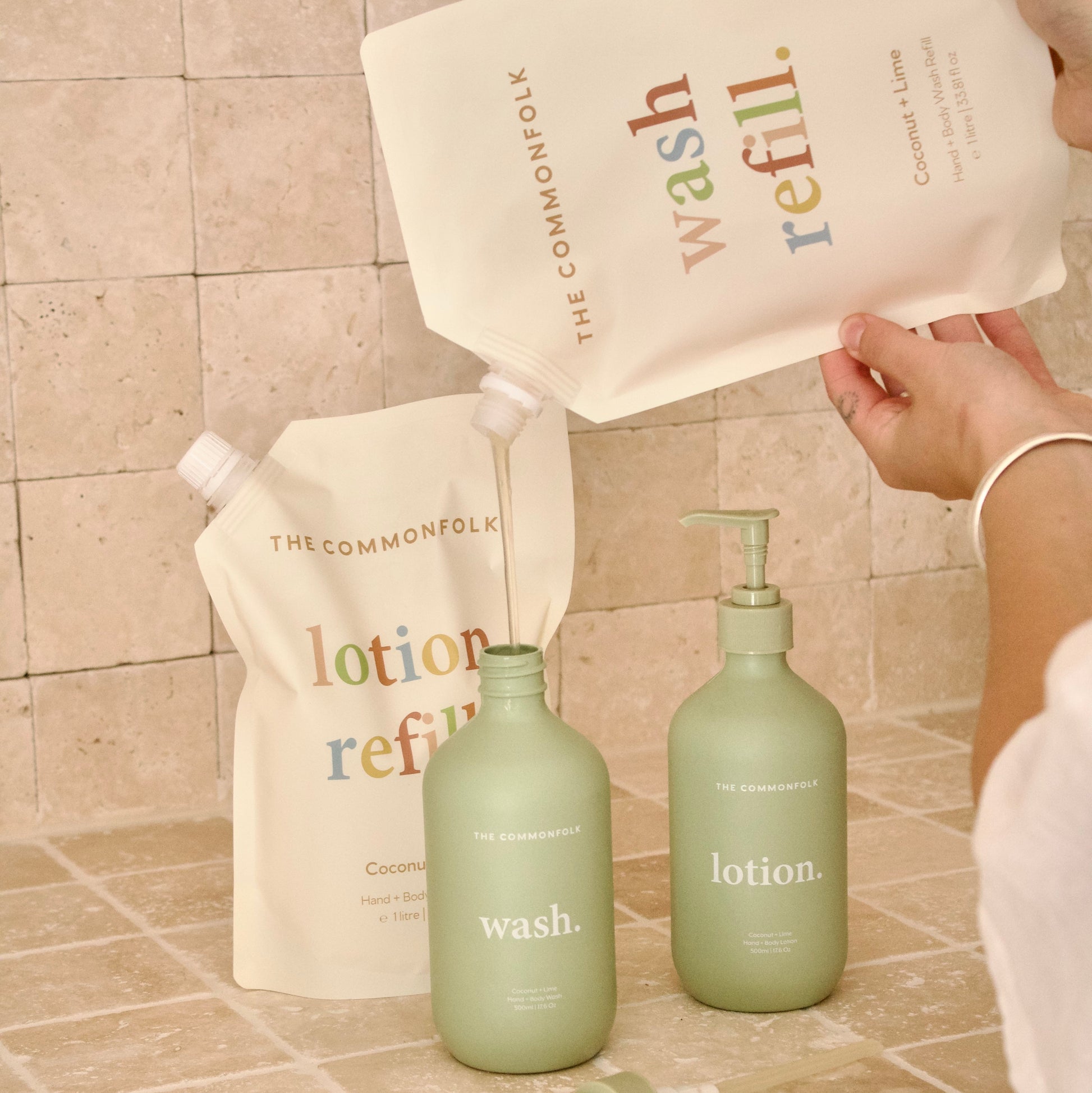 Refillable bottles and containers with 'The Commonfolk' branding on a tiled surface.