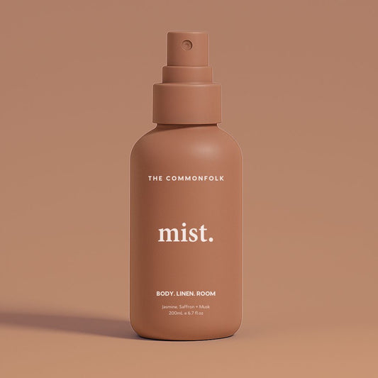 Rose pink mist spray bottle labeled 'The Commonfolk' on a pink background