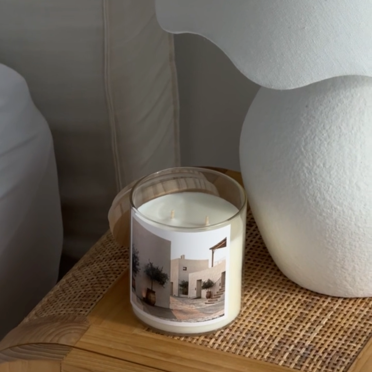 Candle on a wooden surface next to a white lamp