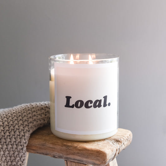 Local candle displayed on a wooden table, showcasing its unique design and warm, inviting colors.